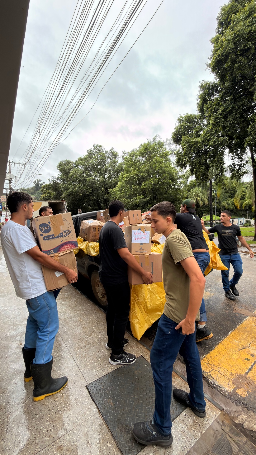 Jovens carregando caixas com doações para as famílias