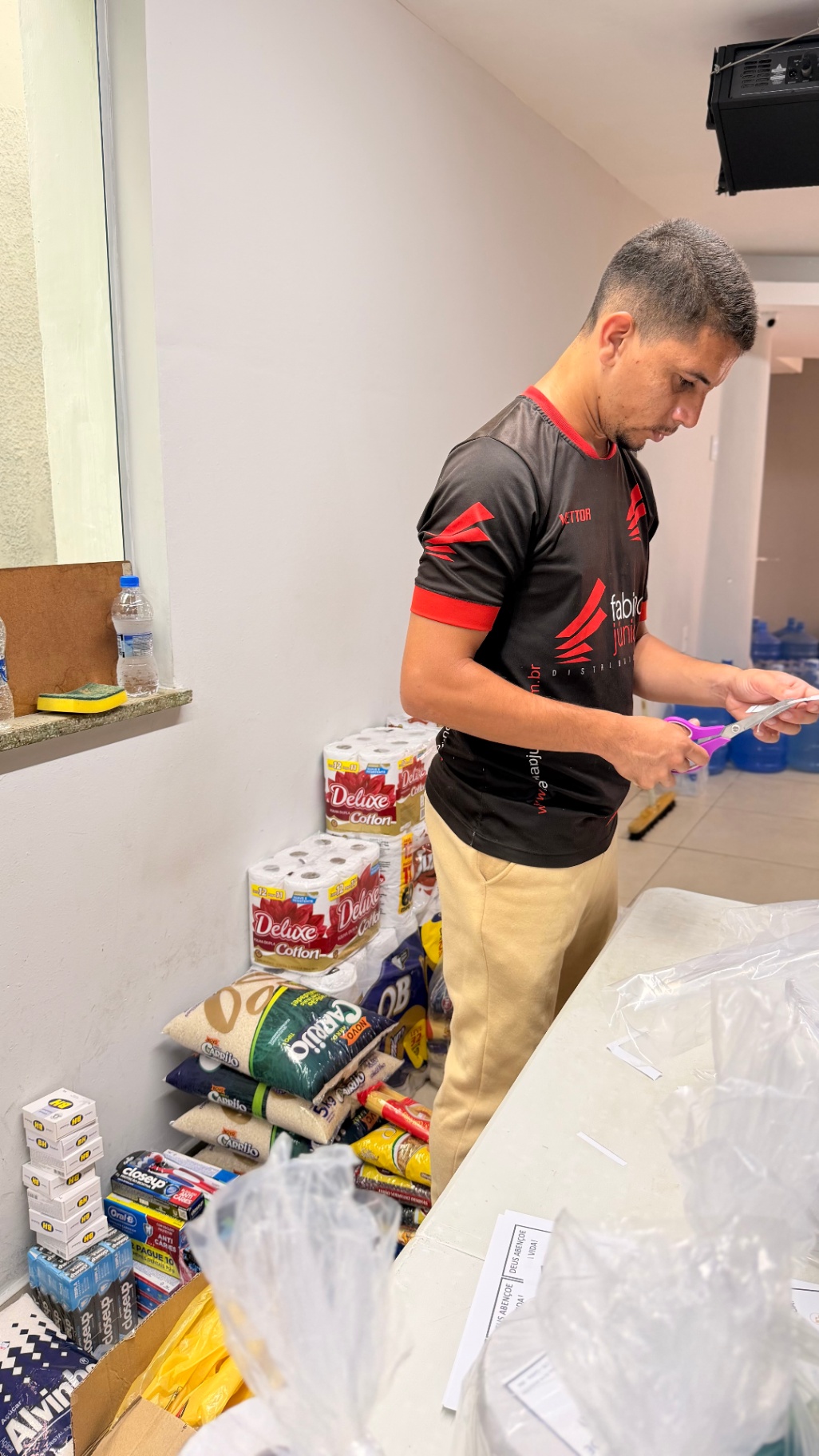Voluntário separando itens de cestas básicas