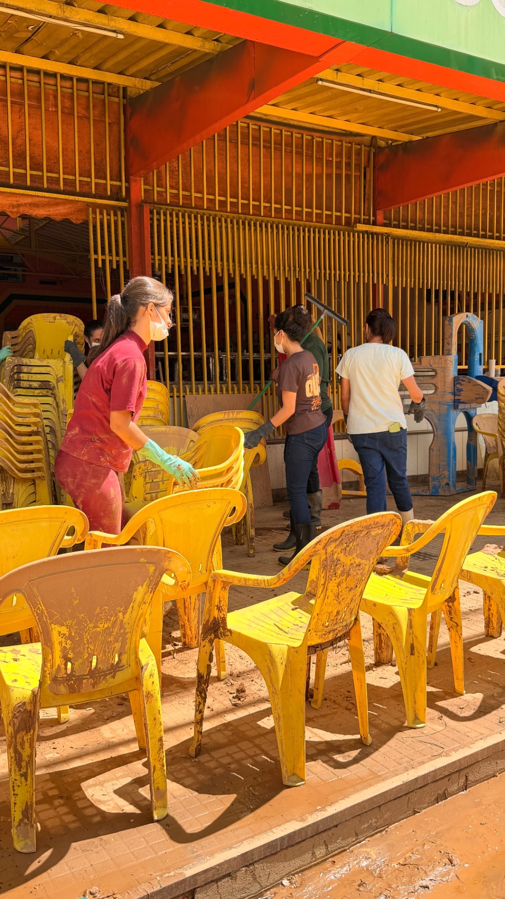 Jovens limpando mobiliário coberto de lama